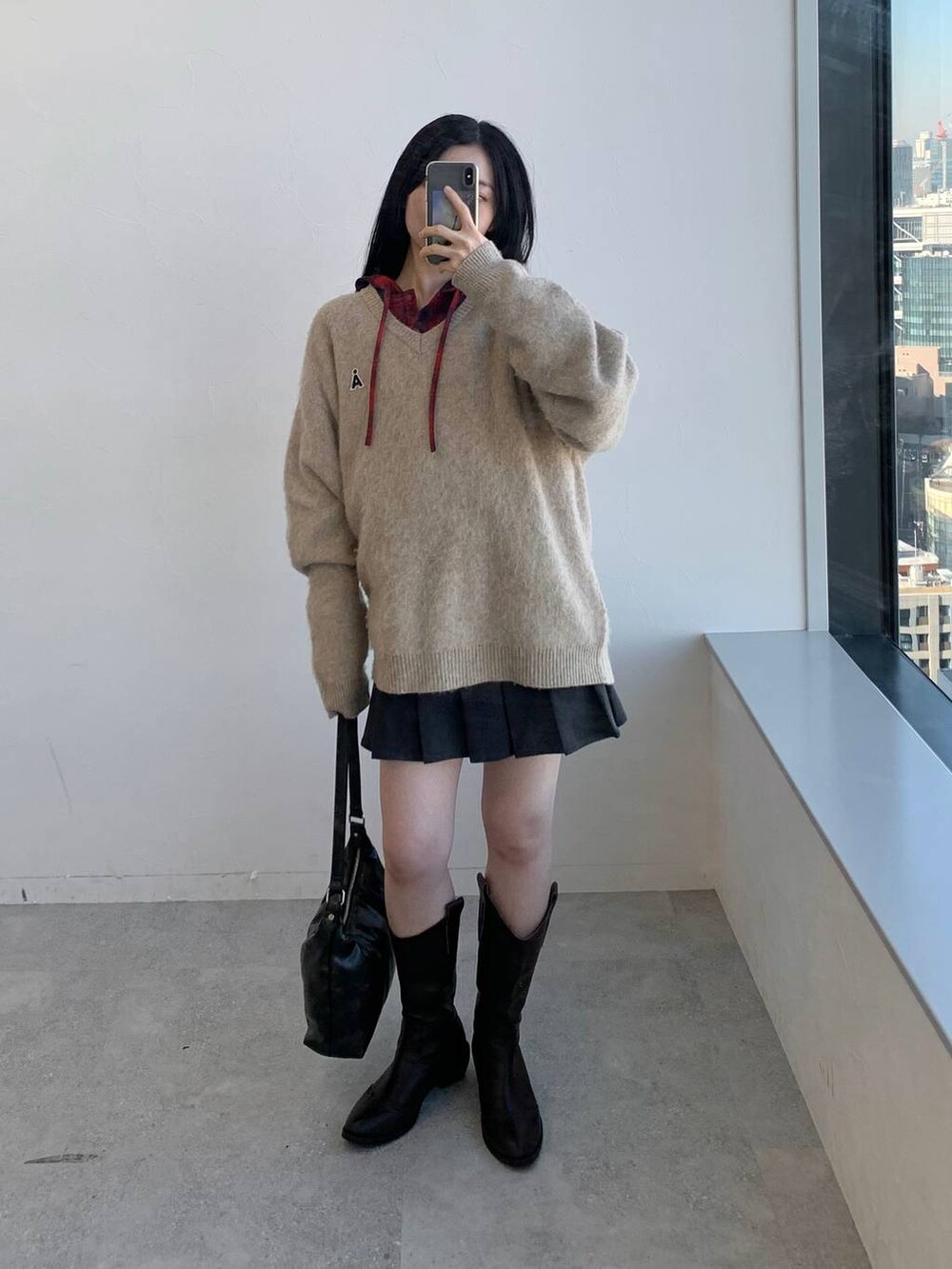 レッド系のシャツ/ブラウス、グレー系のスカート、ブラック系のハンドバッグを着用したレディースの冬コーディネートの2枚目の写真