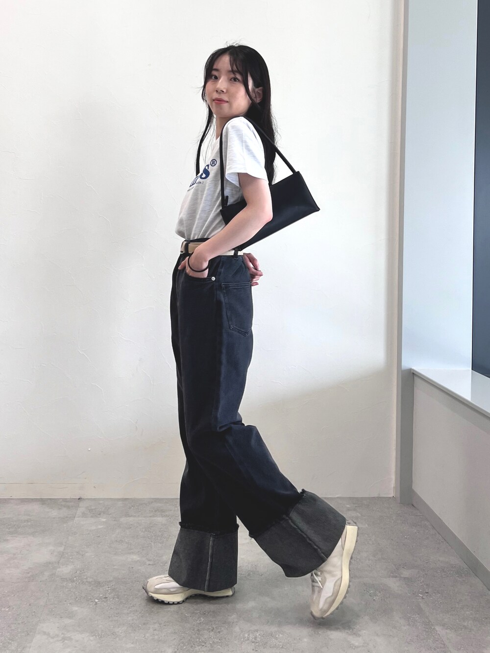 ブラック系のデニムパンツ、ホワイト系のスニーカー、グレー系のTシャツ/カットソーを着用したレディースの夏コーディネートの3枚目の写真