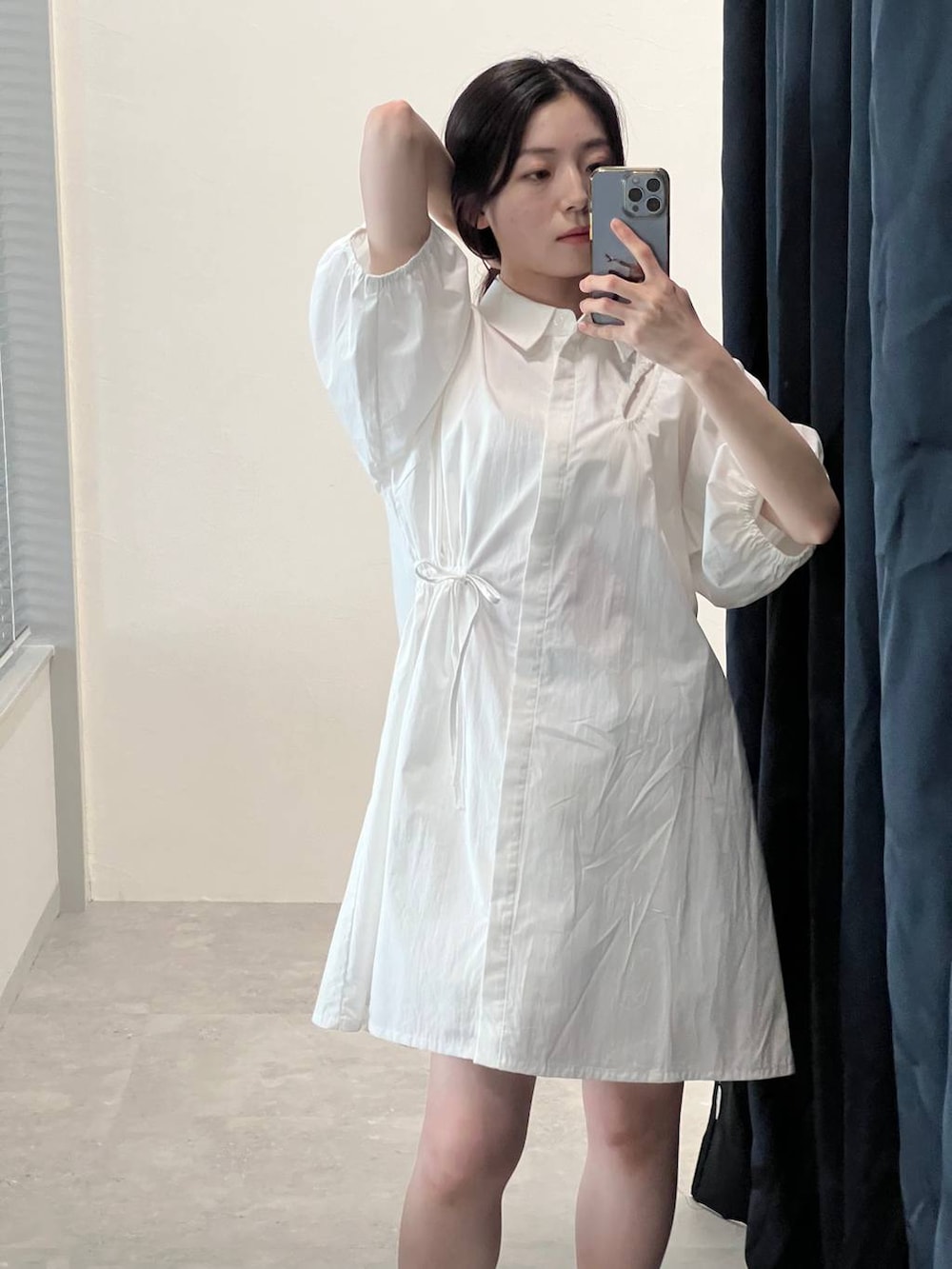 ホワイト系のシャツワンピースを着用したレディースの夏コーディネートの3枚目の写真