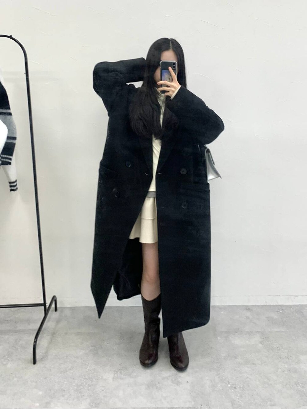 シルバー系のショルダーバッグ、ベージュ系のTシャツ/カットソー、ホワイト系のスカートを着用したレディースの冬コーディネートの5枚目の写真