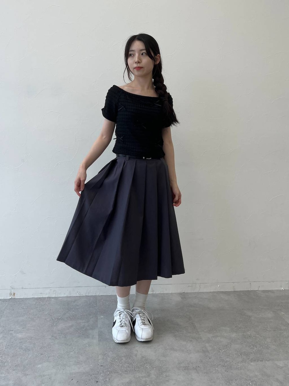 グレー系のスカート、ブラック系のTシャツ/カットソーを着用したレディースの夏コーディネートの3枚目の写真