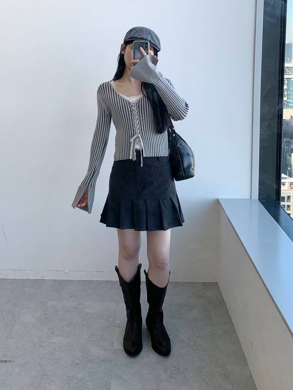 グレー系のカーディガン/ボレロ、グレー系のスカート、ブラック系のハンドバッグを着用したレディースの冬コーディネートの3枚目の写真