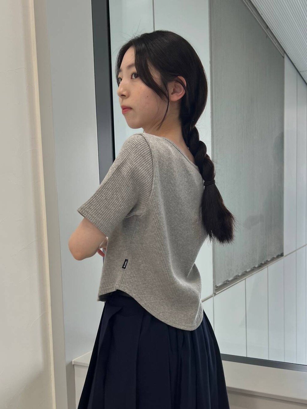 ブルー系のスカート、ブルー系のトートバッグ、グレー系のTシャツ/カットソーを着用したレディースの夏コーディネートの7枚目の写真