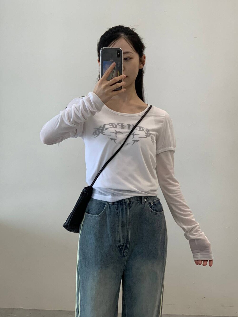 その他のデニムパンツ、ホワイト系のTシャツ/カットソー、ブラック系のショルダーバッグを着用したレディースの秋コーディネートの5枚目の写真