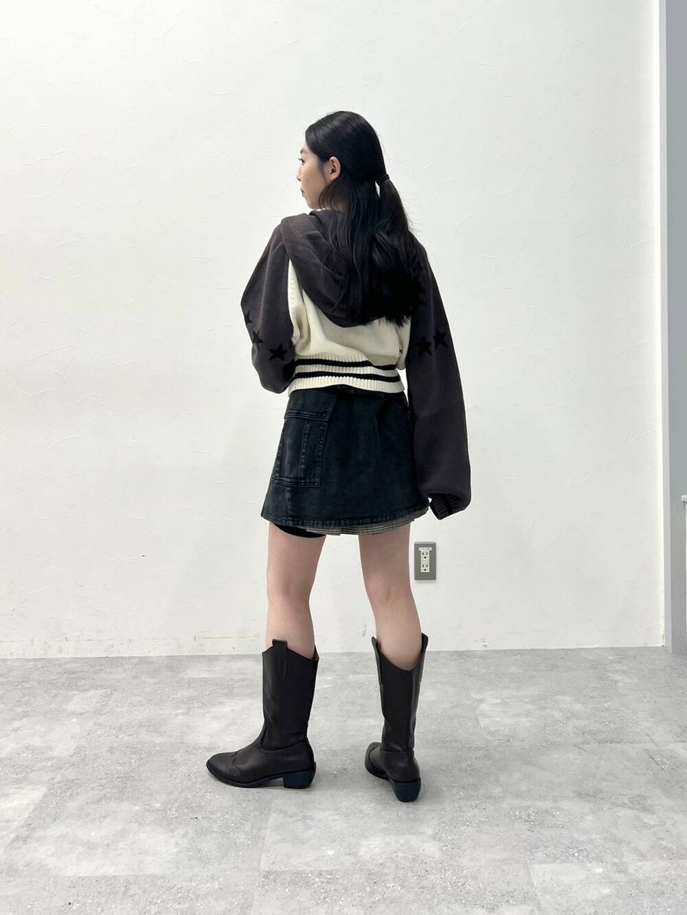 ブラウン系のスカート、ブラック系のデニムパンツを着用したレディースの春コーディネートの6枚目の写真