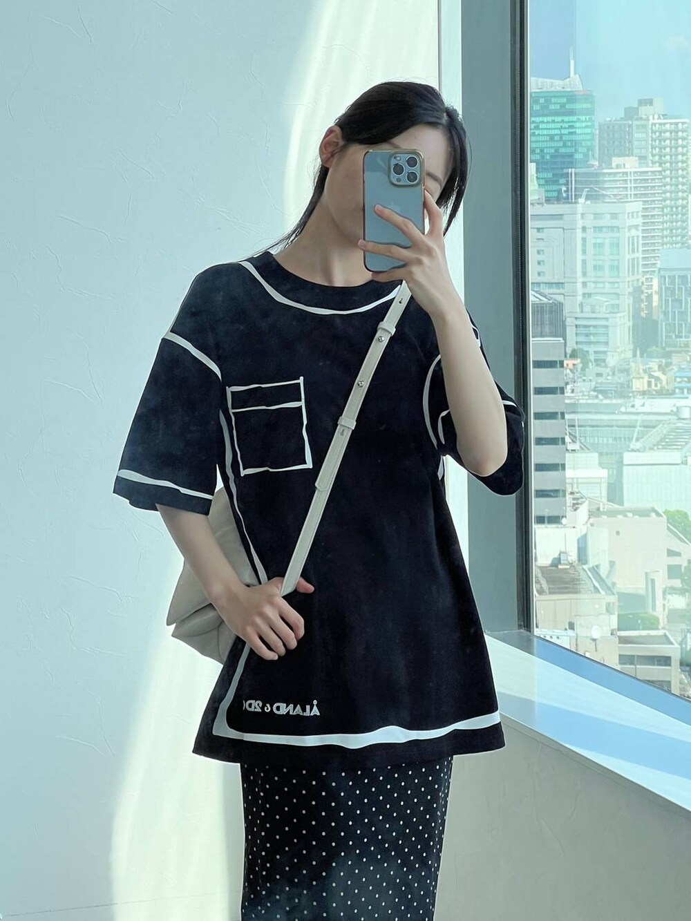 ホワイト系のハンドバッグ、ブラック系のスカートを着用したレディースの夏コーディネートの7枚目の写真