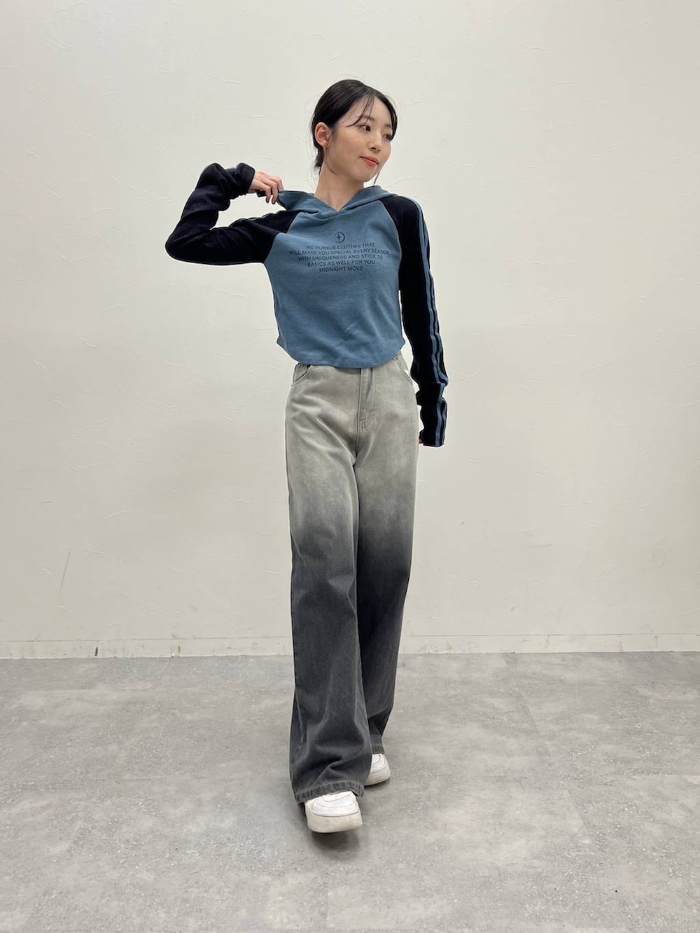 ブラック系のデニムパンツ、ホワイト系のスニーカー、ブルー系のTシャツ/カットソーを着用したレディースの冬コーディネートの3枚目の写真