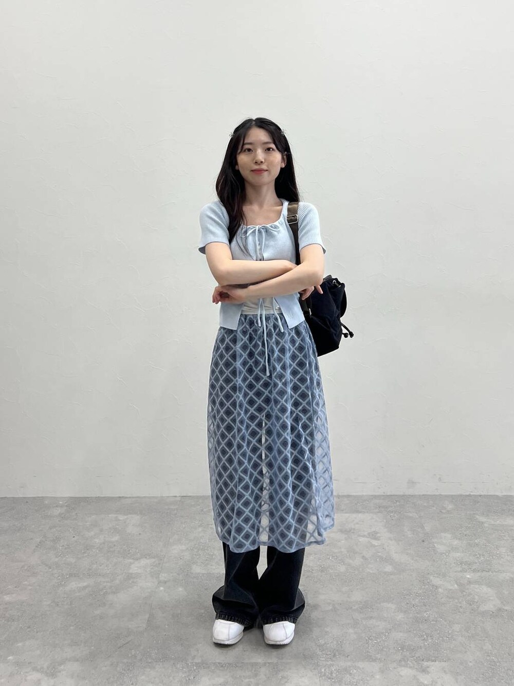 ブルー系のスカート、ブラック系のデニムパンツ、ブルー系のカーディガン/ボレロを着用したレディースの春コーディネートの2枚目の写真