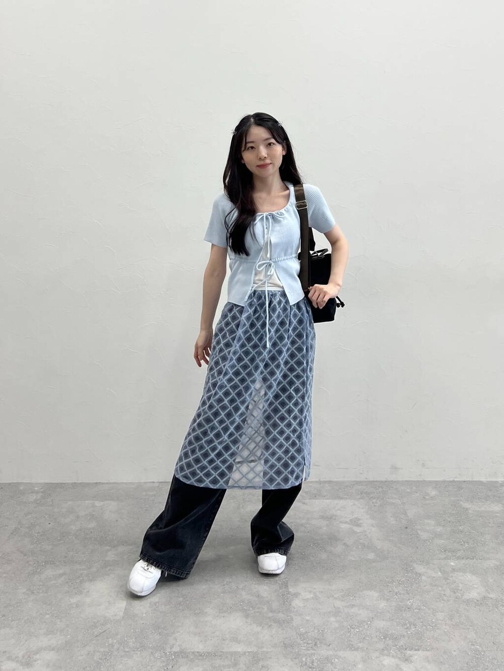 ブルー系のスカート、ブラック系のデニムパンツ、ブルー系のカーディガン/ボレロを着用したレディースの春コーディネートの6枚目の写真