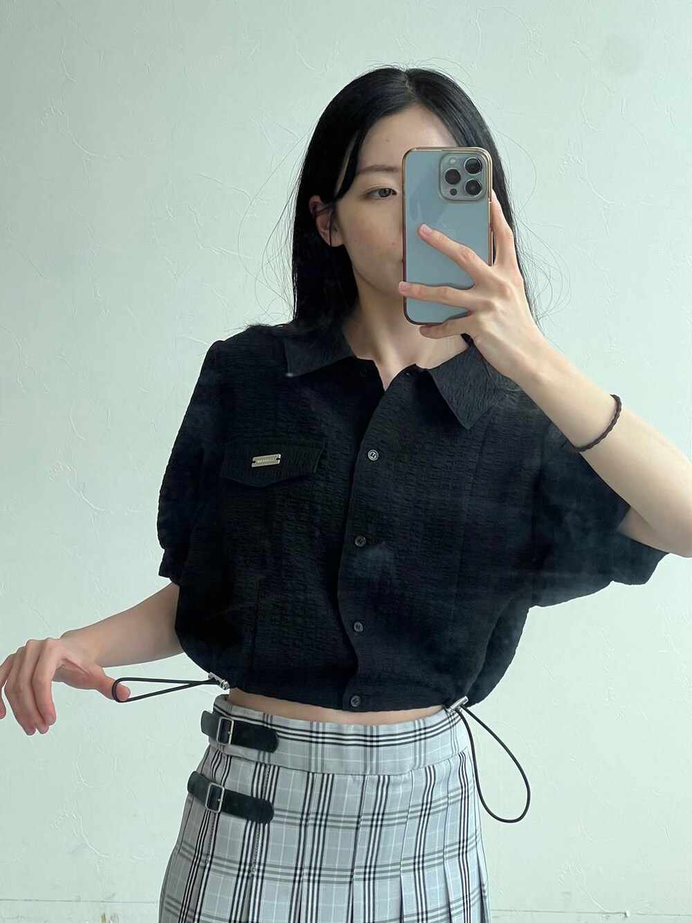 ブルー系のスカート、ブラック系のシャツ/ブラウス、ブラック系のショルダーバッグを着用したレディースの夏コーディネートの2枚目の写真