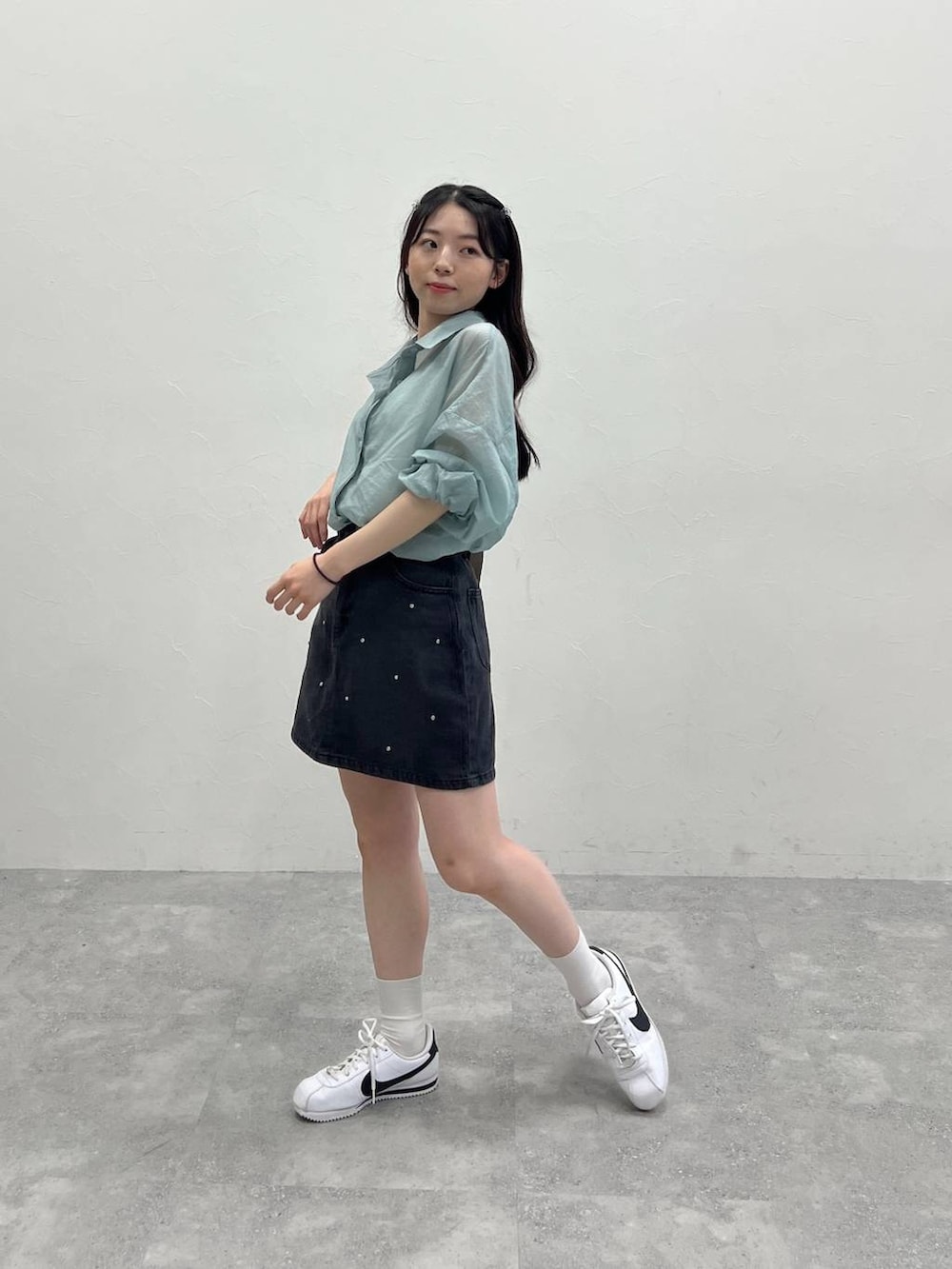 ブラック系のデニムスカート、ブルー系のシャツ/ブラウスを着用したレディースの春コーディネートの2枚目の写真