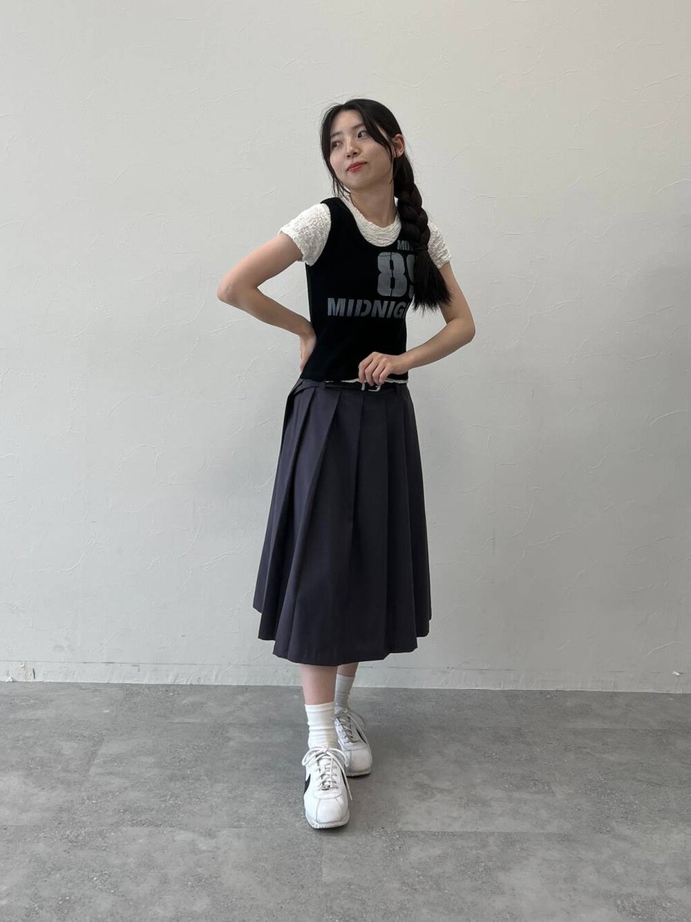 グレー系のスカート、ブラック系のタンクトップ、ホワイト系のTシャツ/カットソーを着用したレディースの夏コーディネートの2枚目の写真