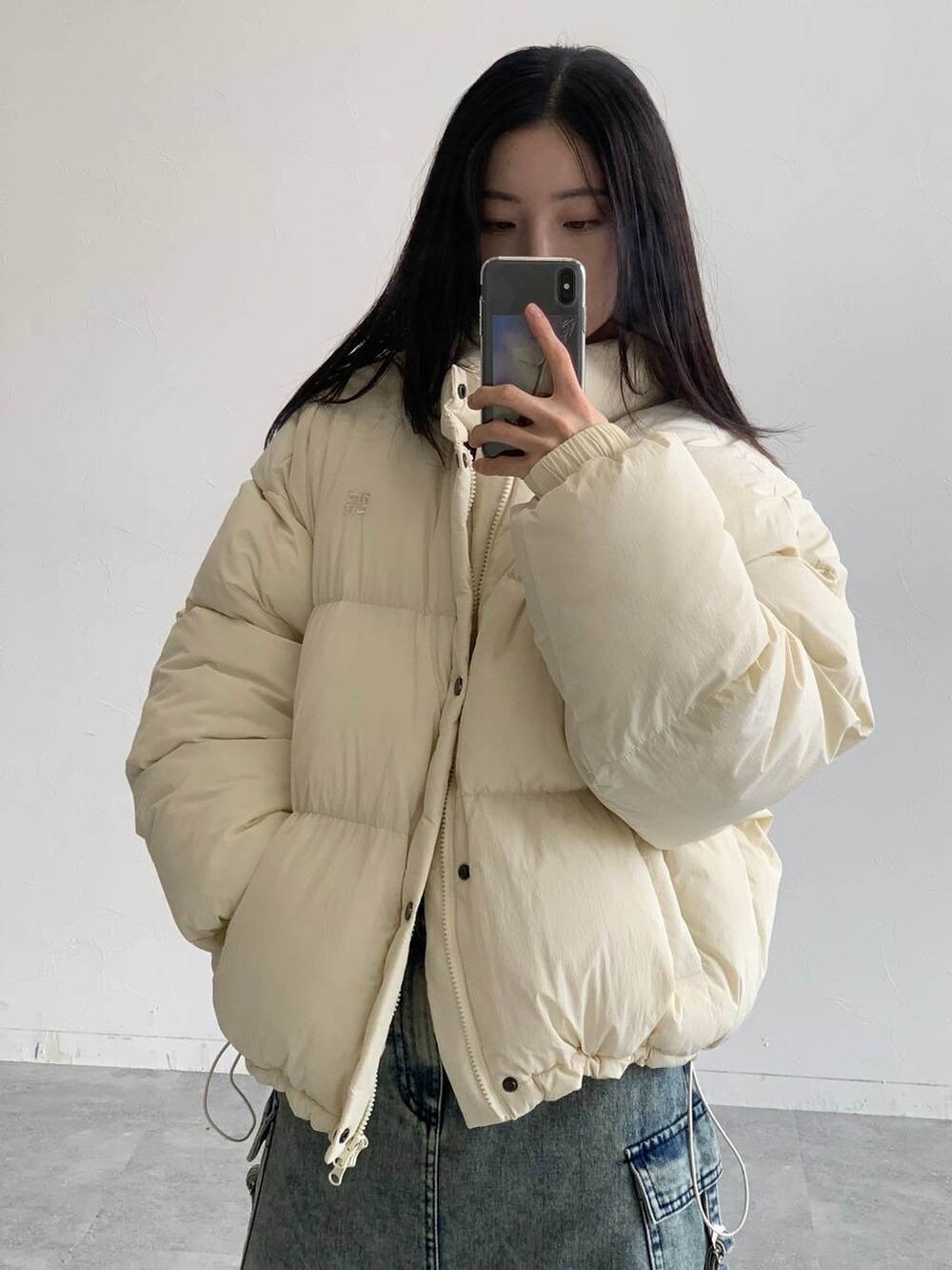 ブルー系のデニムスカート、ベージュ系のダウンジャケット/コートを着用したレディースの秋コーディネートの7枚目の写真