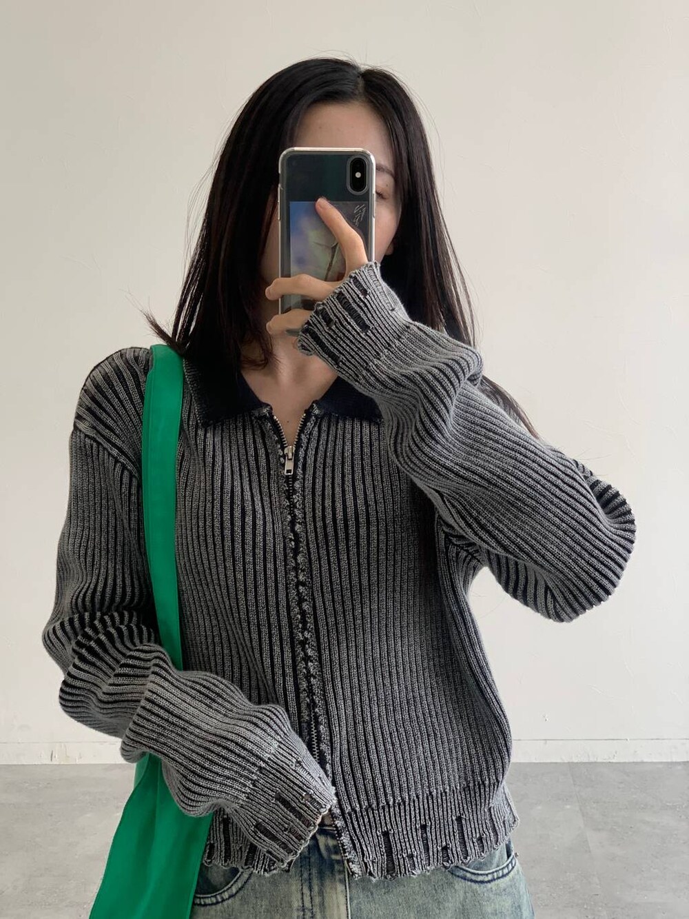 ブルー系のデニムスカート、グリーン系のトートバッグ、ブラック系のニット/セーターを着用したレディースの秋コーディネートの7枚目の写真