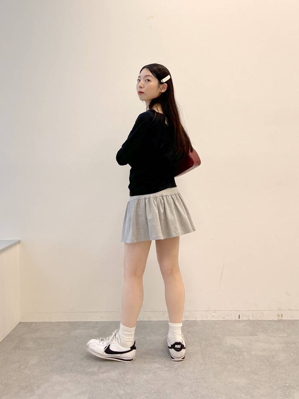 グレー系のスカート、ブラック系のTシャツ/カットソーを着用したレディースの夏コーディネートの3枚目の写真