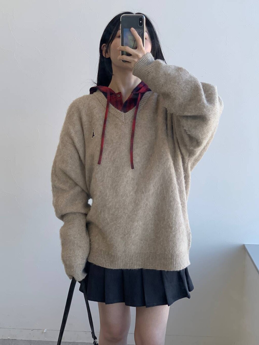 レッド系のシャツ/ブラウス、グレー系のスカート、ブラック系のハンドバッグを着用したレディースの冬コーディネートの5枚目の写真