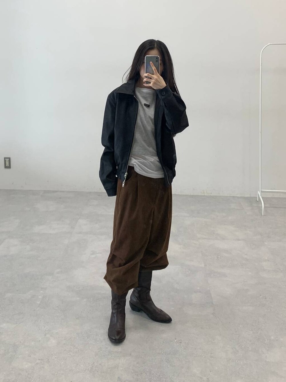 ホワイト系のTシャツ/カットソー、ブラック系のライダースジャケット、ブラウン系のその他パンツを着用したレディースの秋コーディネートの3枚目の写真