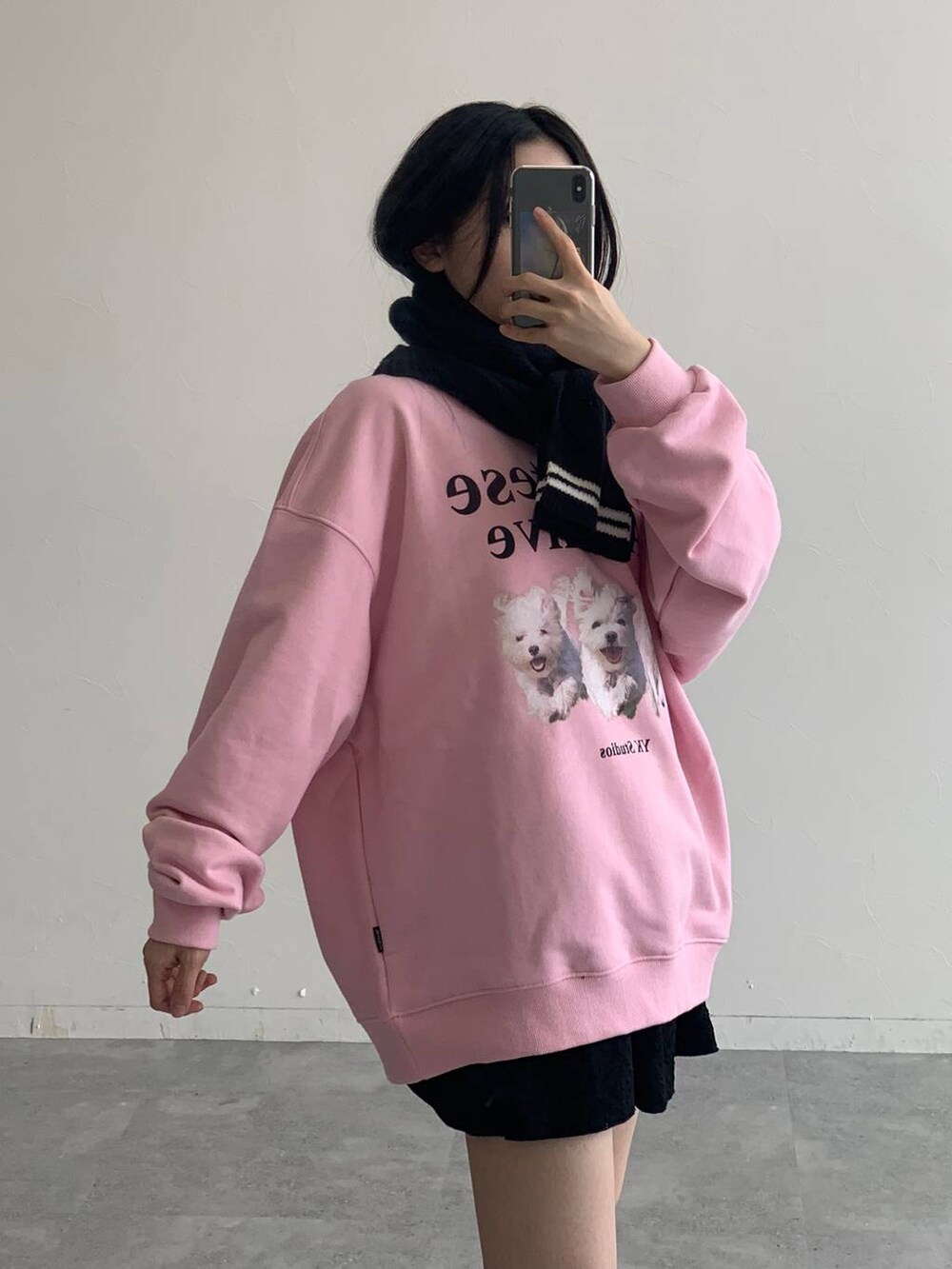 ブラック系のスカート、ピンク系のスウェット、ブラック系のマフラーを着用したレディースの秋コーディネートの7枚目の写真