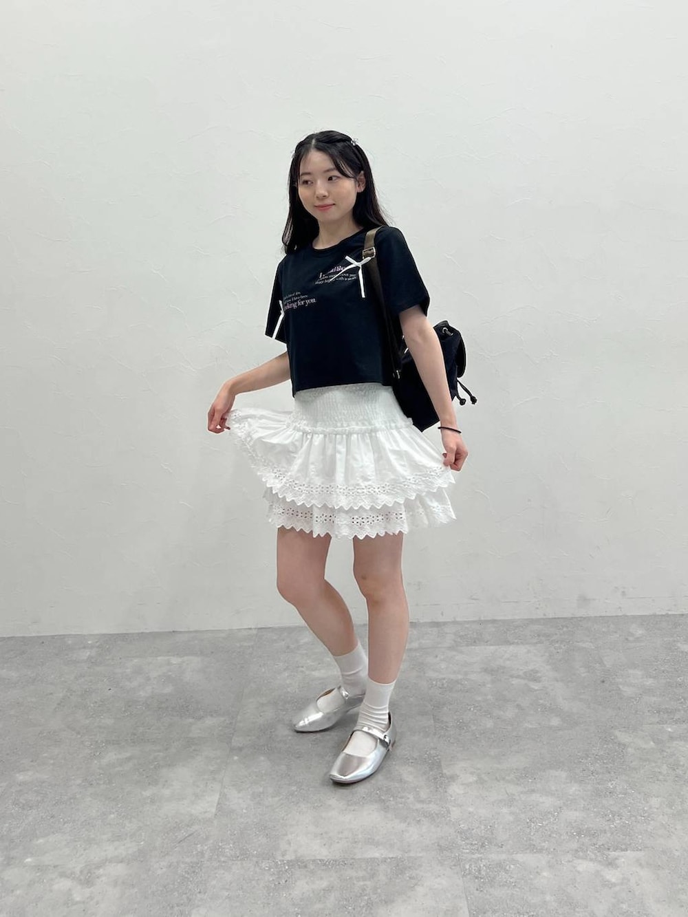 ホワイト系のスカート、ブラック系のナイロンジャケット、ブラック系のTシャツ/カットソーを着用したレディースの春コーディネートの5枚目の写真