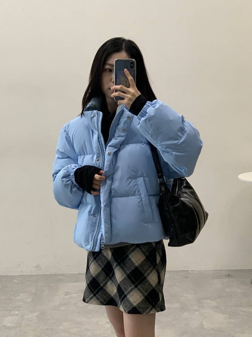 ブラック系のスカート、ブラック系のハンドバッグ、ブラック系のTシャツ/カットソーを着用したレディースの冬コーディネートの7枚目の写真