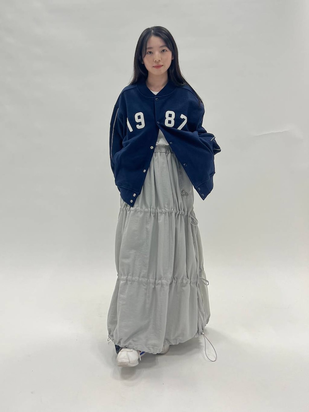 ホワイト系のTシャツ/カットソー、ブラック系のデニムパンツ、ブルー系のブルゾンを着用したレディースの冬コーディネートの6枚目の写真