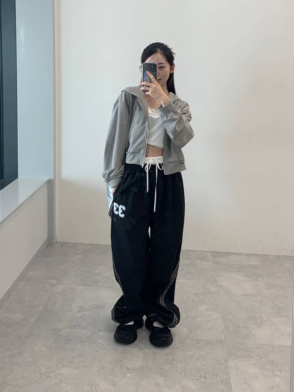 グレー系のパーカー、グレー系のバックパック/リュック、ブラック系のその他パンツを着用したレディースの秋コーディネートの2枚目の写真