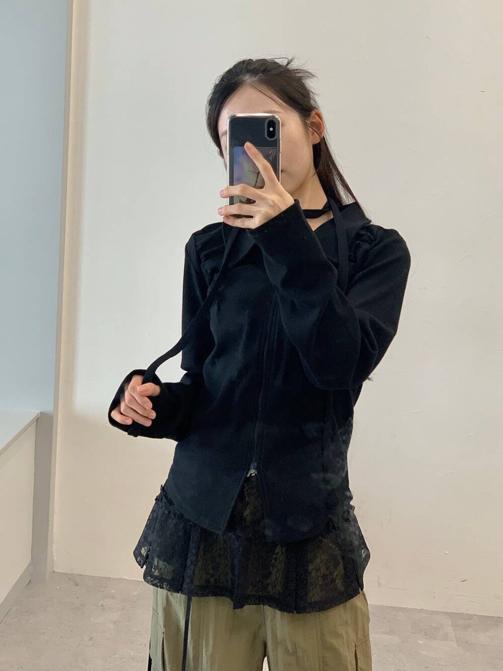 グリーン系のカーゴパンツ、ブラック系のスカート、ブラック系のTシャツ/カットソーを着用したレディースの秋コーディネートの5枚目の写真