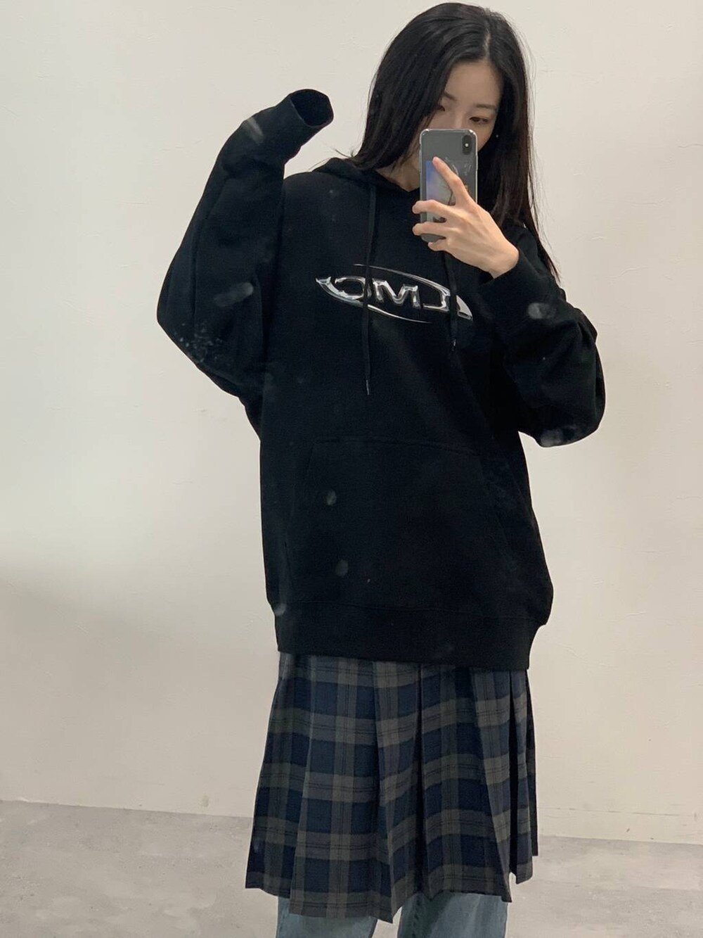 グレー系のスカート、ブラック系のパーカーを着用したレディースの秋コーディネートの3枚目の写真