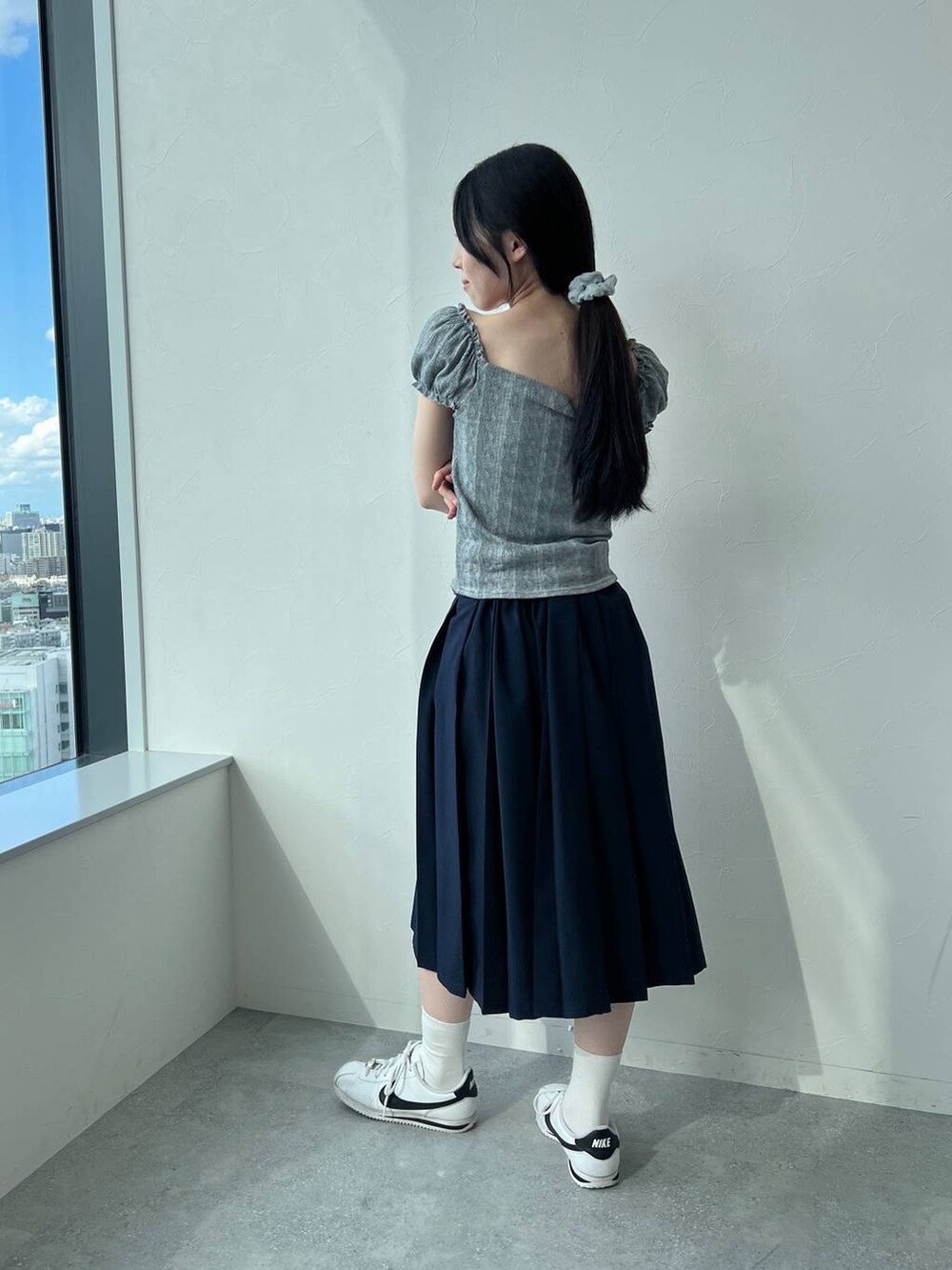 ブルー系のスカート、グレー系のTシャツ/カットソーを着用したレディースの夏コーディネートの5枚目の写真