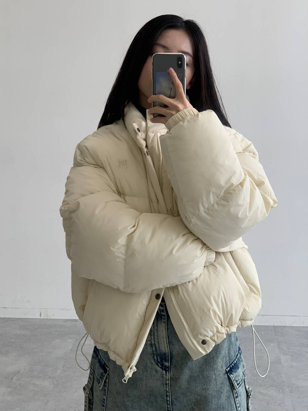 ブルー系のデニムスカート、ベージュ系のダウンジャケット/コートを着用したレディースの秋コーディネートの6枚目の写真