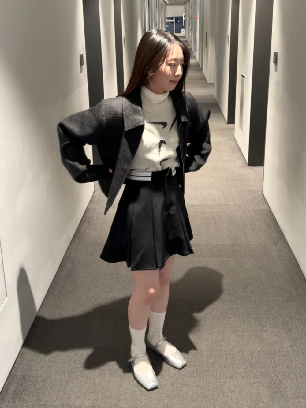 ブラック系のスカート、ブラック系のブルゾン、ブラウン系のTシャツ/カットソーを着用したレディースの春コーディネートの2枚目の写真