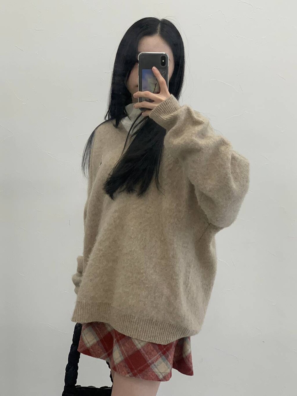 ブラック系のショルダーバッグ、レッド系のスカート、ベージュ系のTシャツ/カットソーを着用したレディースの冬コーディネートの4枚目の写真