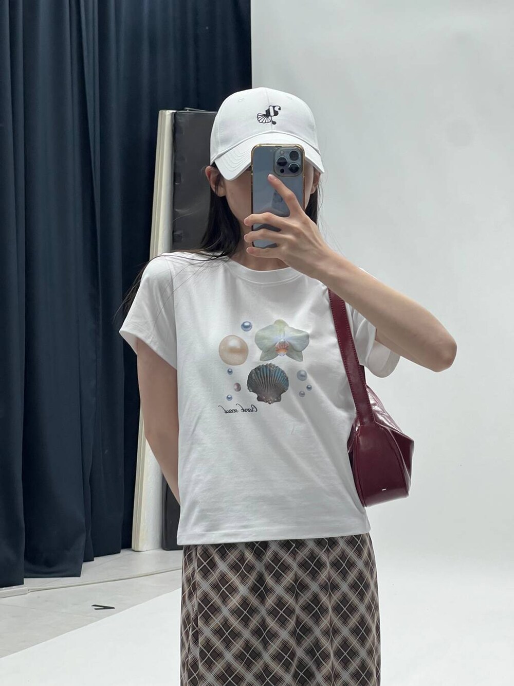 ブラウン系のスカート、ホワイト系のTシャツ/カットソーを着用したレディースの夏コーディネートの3枚目の写真