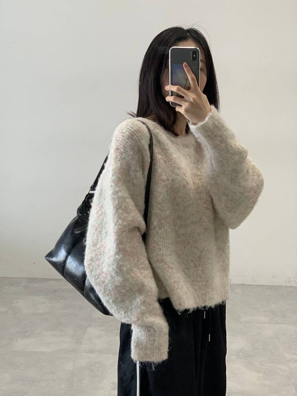 ブラック系のその他パンツ、ホワイト系のニット/セーター、ブラック系のハンドバッグを着用したレディースの秋コーディネートの6枚目の写真