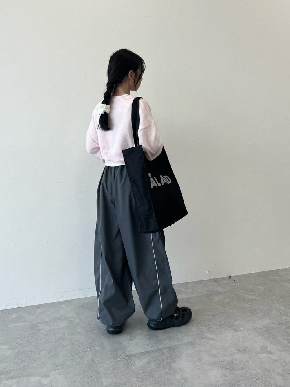 ブラック系のスニーカー、グレー系のその他パンツ、ブルー系のバッグを着用したレディースの冬コーディネートの2枚目の写真