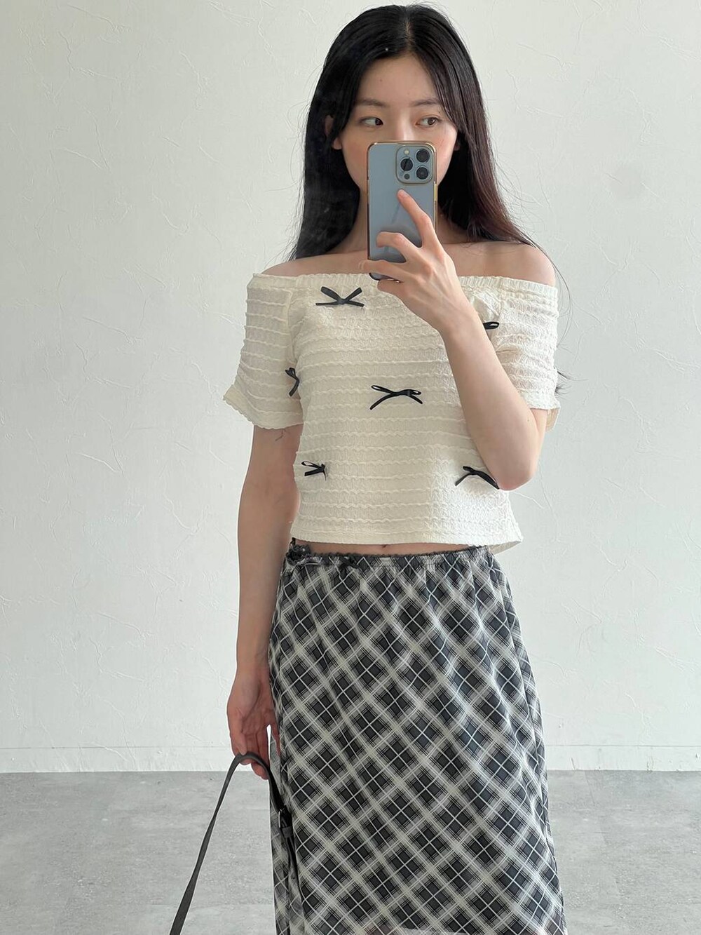 ホワイト系のTシャツ/カットソー、グレー系のスカート、ブラック系のトートバッグを着用したレディースの夏コーディネートの7枚目の写真