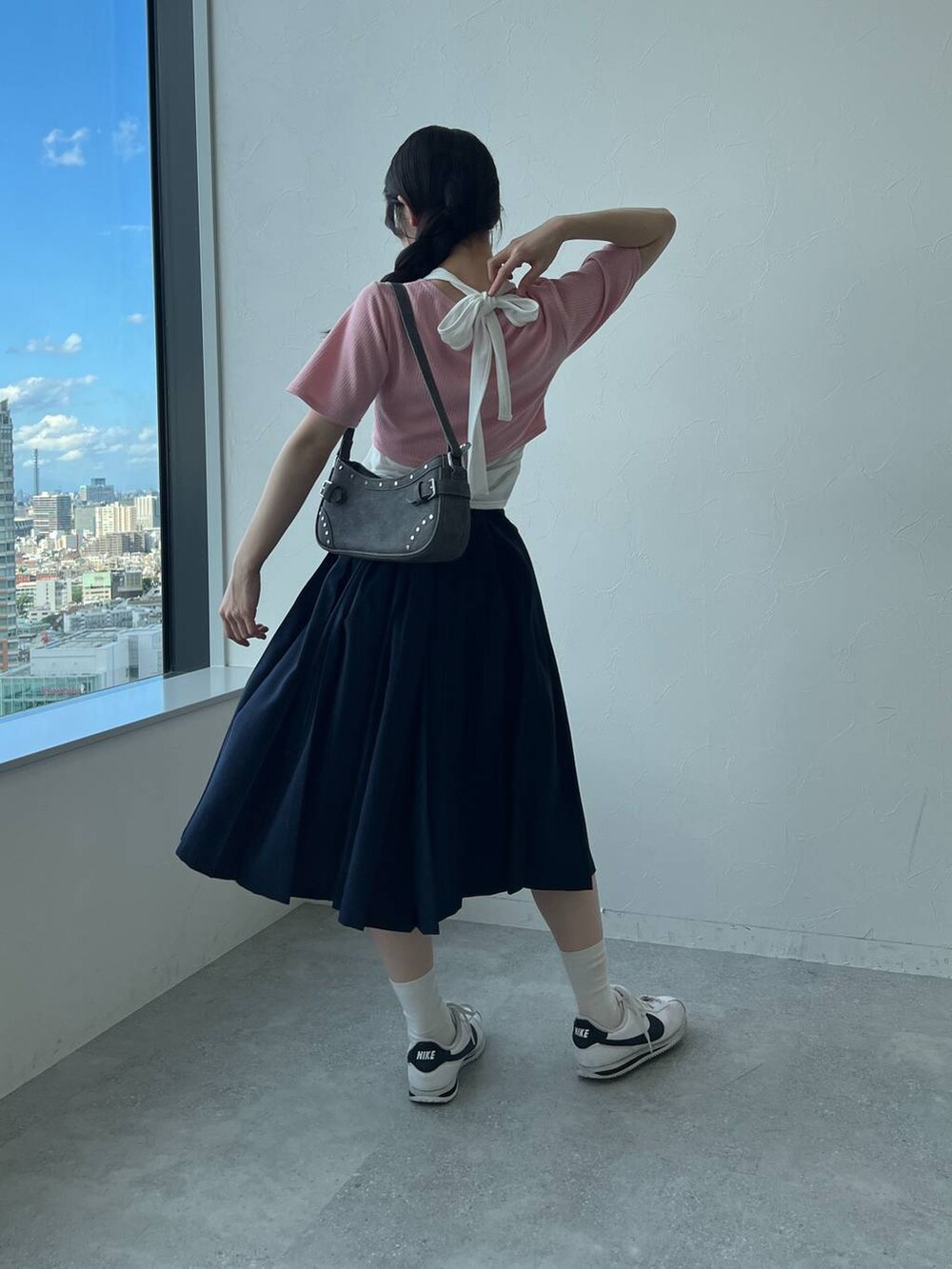 ブルー系のスカート、ブラック系のトートバッグ、ピンク系のカーディガン/ボレロを着用したレディースの夏コーディネートの6枚目の写真