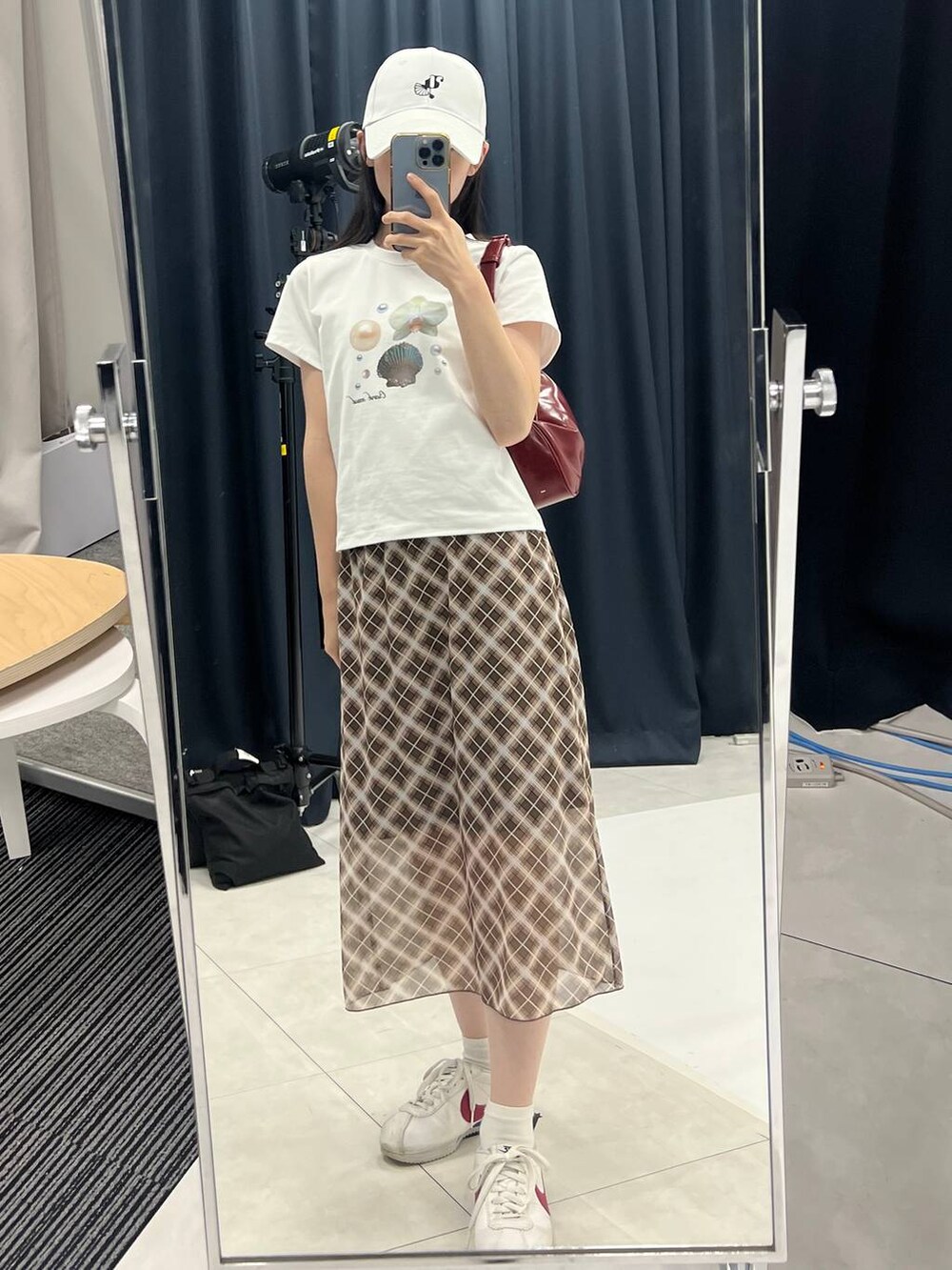 ブラウン系のスカート、ホワイト系のTシャツ/カットソーを着用したレディースの夏コーディネートの4枚目の写真