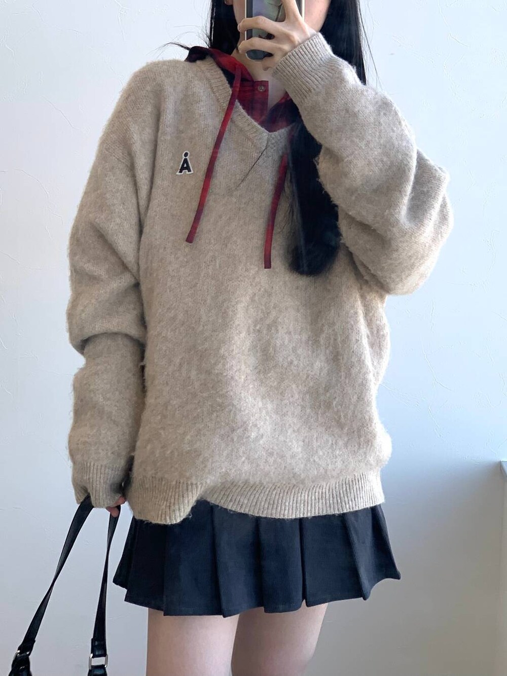 レッド系のシャツ/ブラウス、グレー系のスカート、ブラック系のハンドバッグを着用したレディースの冬コーディネートの8枚目の写真