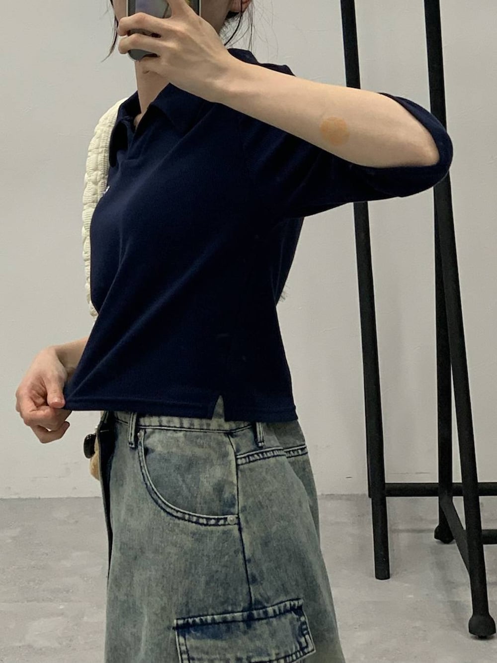 ブルー系のデニムスカート、ホワイト系のショルダーバッグ、ブルー系のTシャツ/カットソーを着用したレディースの秋コーディネートの7枚目の写真