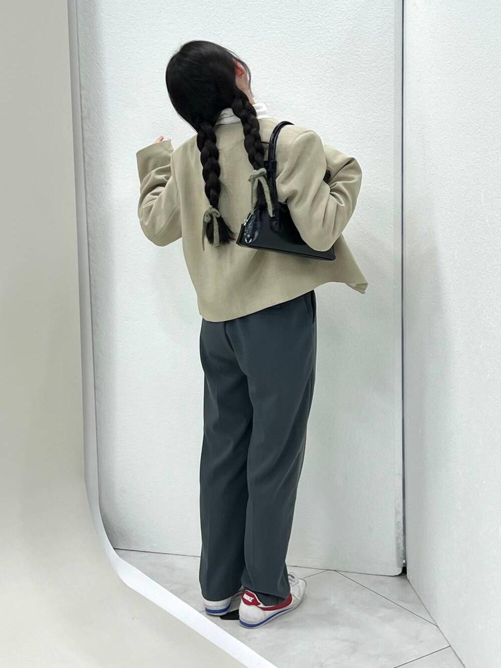 ベージュ系のTシャツ/カットソー、ベージュ系のノーカラージャケット、ピンク系のニット/セーターを着用したレディースの冬コーディネートの2枚目の写真