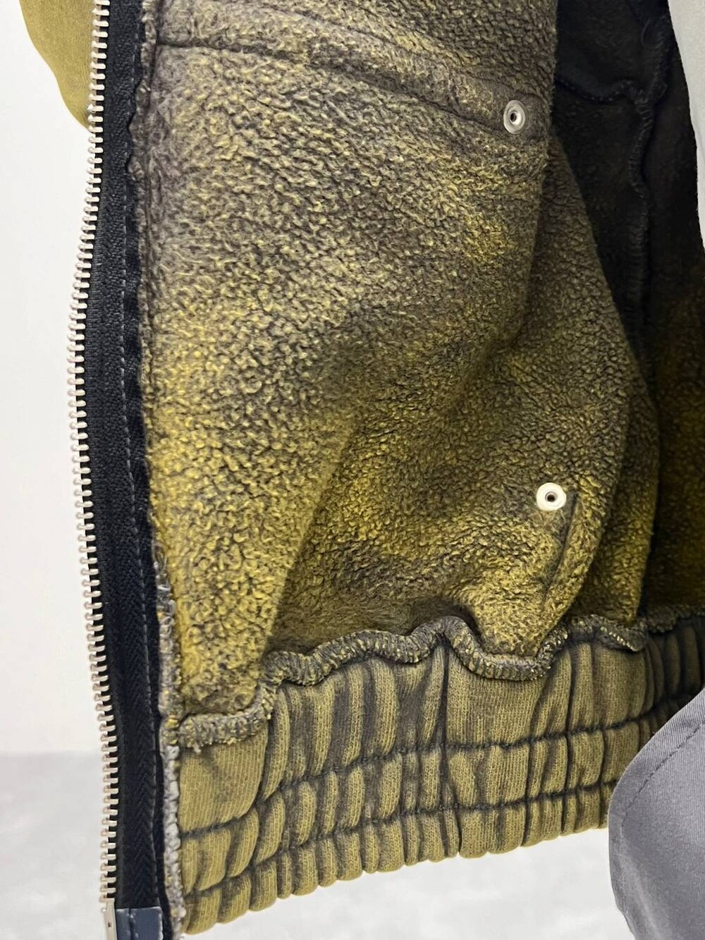 グレー系のスカート、ブラック系のローファー、グリーン系のパーカーを着用したレディースの冬コーディネートの2枚目の写真