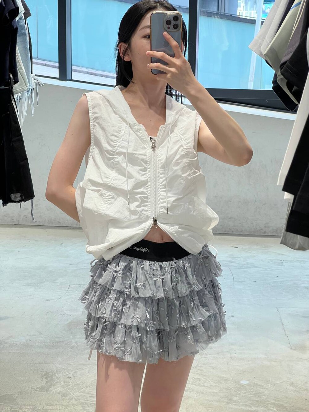 ホワイト系のスカート、ホワイト系のベストを着用したレディースの夏コーディネートの4枚目の写真