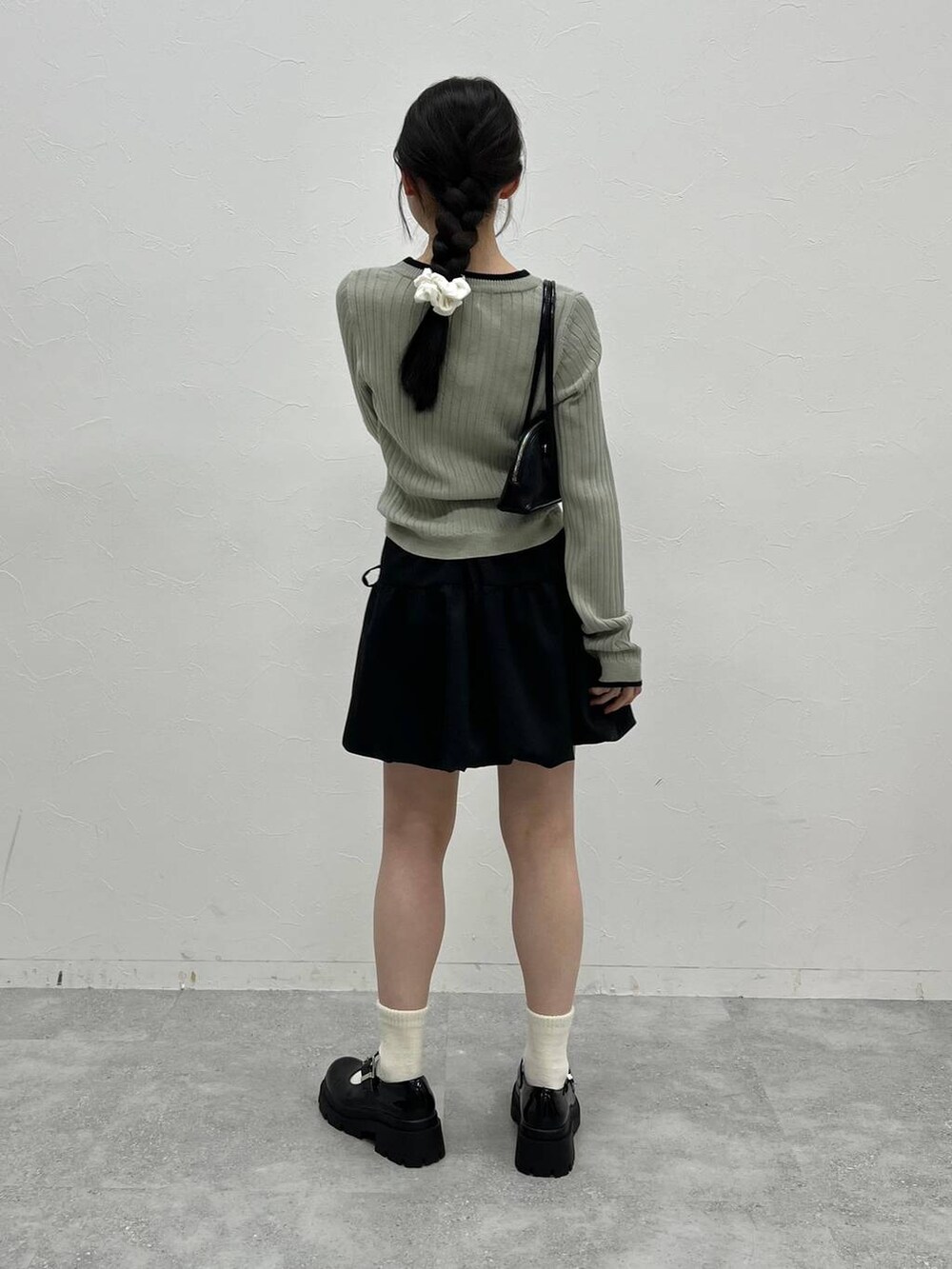 グレー系のTシャツ/カットソー、ブラック系のハンドバッグを着用したレディースの冬コーディネートの6枚目の写真