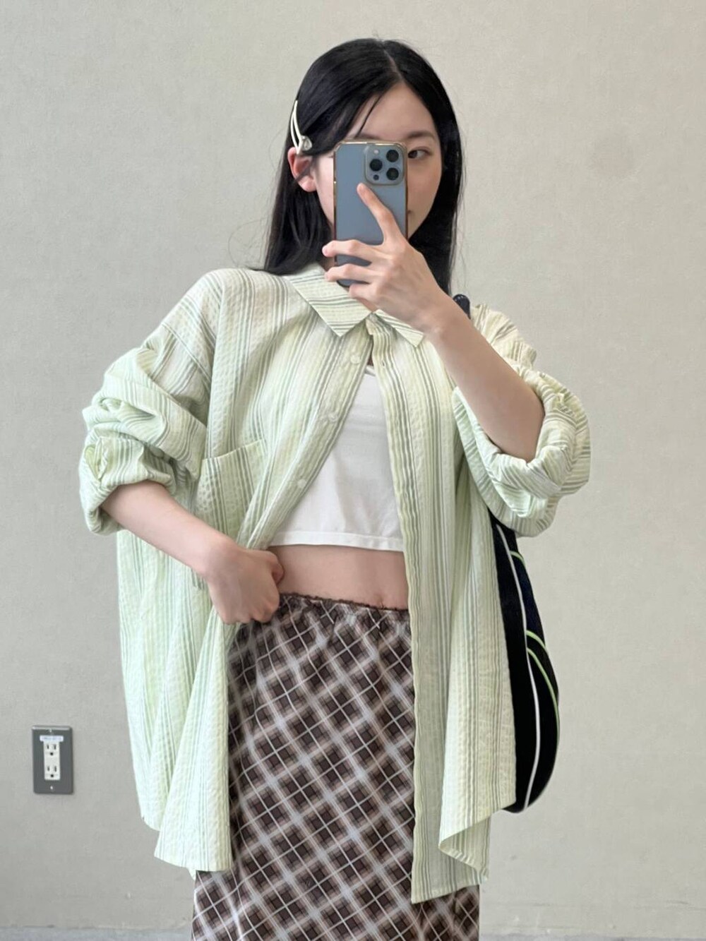 ブラウン系のスカート、グリーン系のシャツ/ブラウスを着用したレディースの夏コーディネートの2枚目の写真