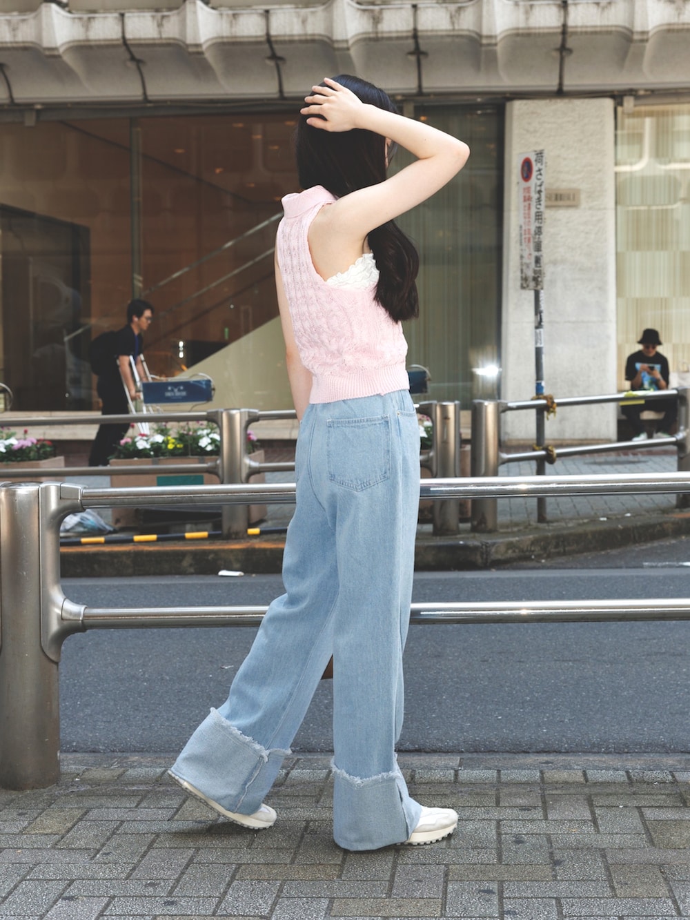 ブルー系のデニムパンツ、ピンク系のニット/セーター、ブラウン系のショルダーバッグを着用したレディースの夏コーディネートの3枚目の写真