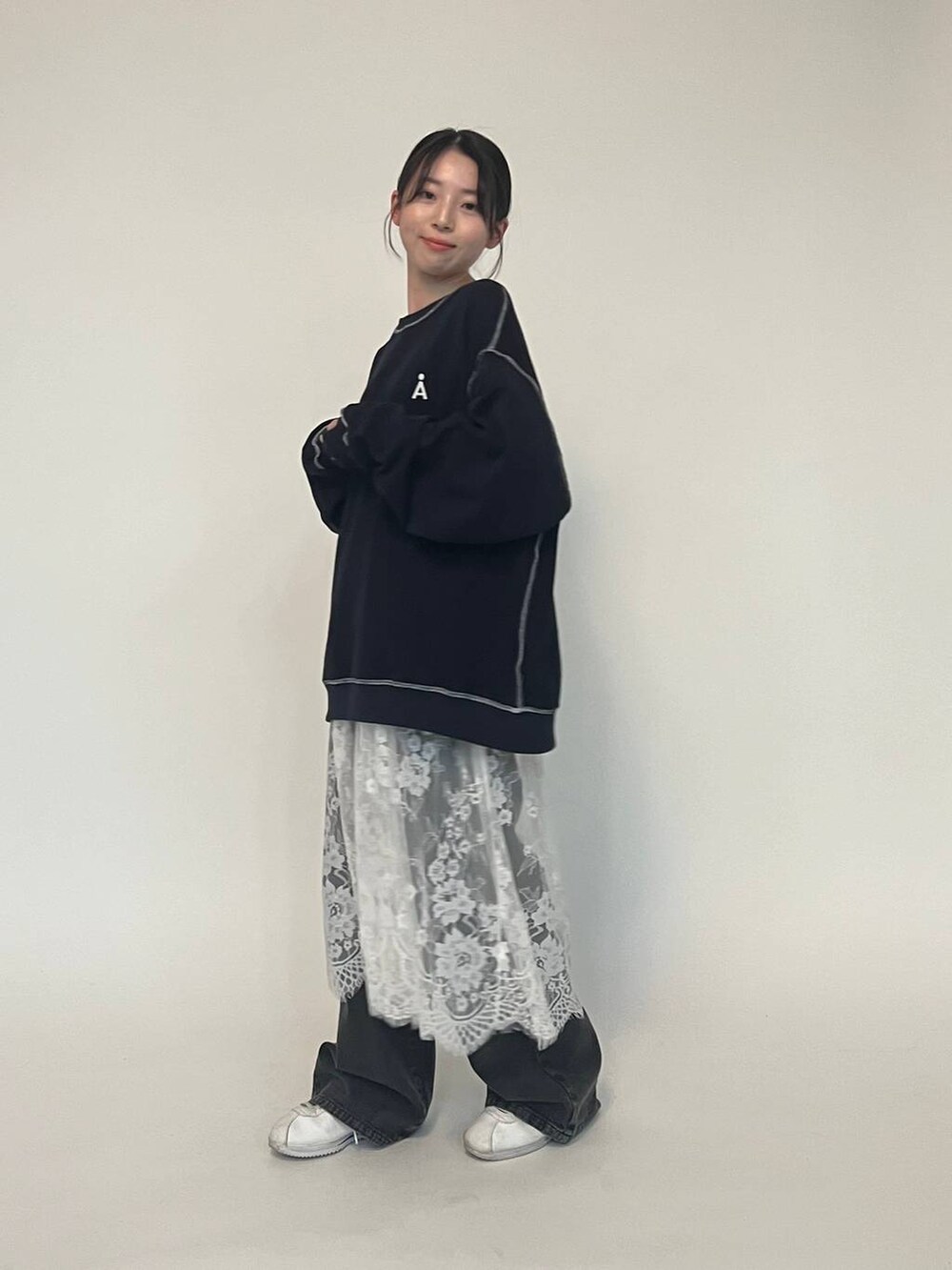 ブラック系のデニムパンツ、ブルー系のパーカー、ホワイト系のスニーカーを着用したレディースの冬コーディネートの7枚目の写真