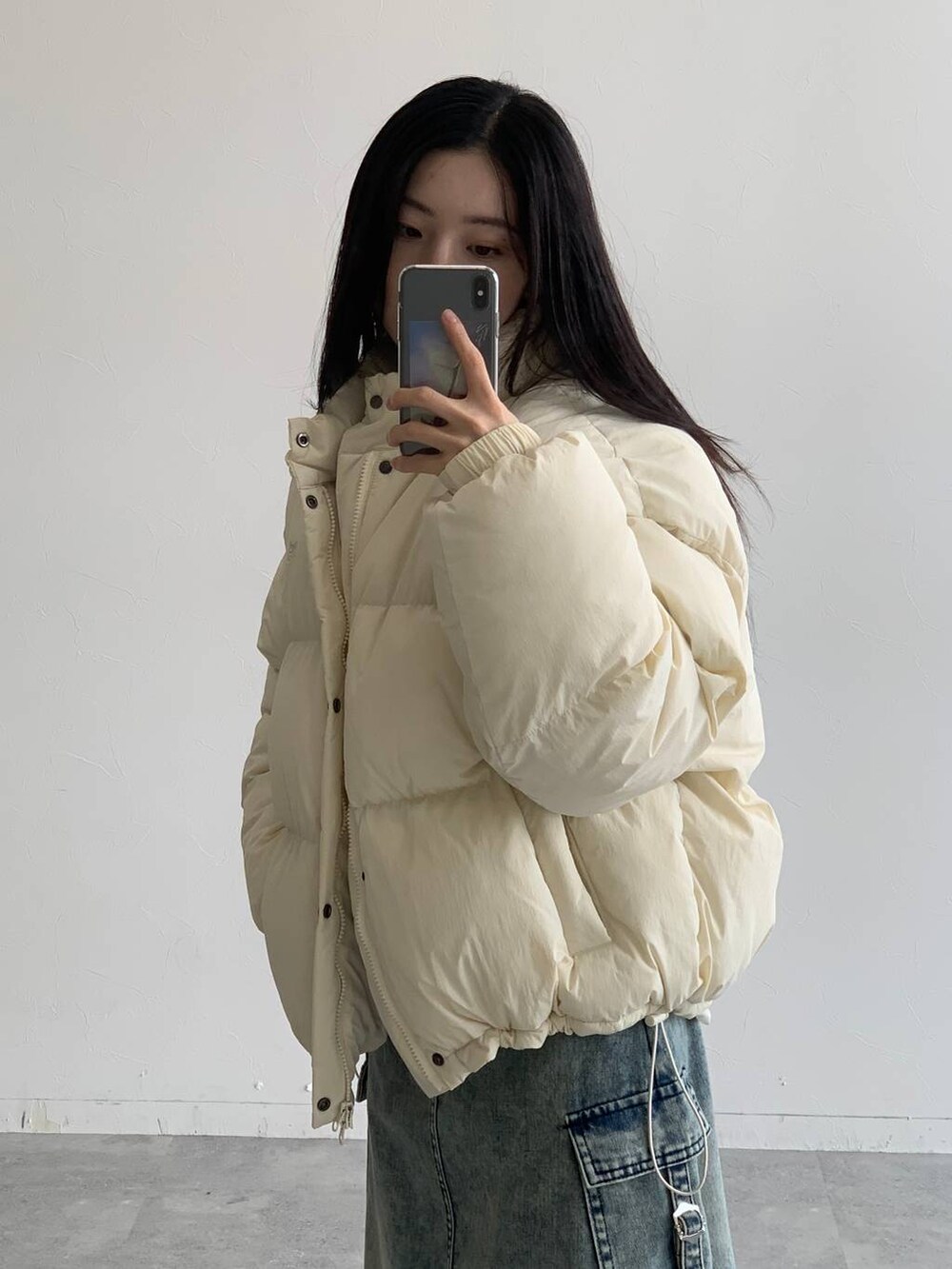 ブルー系のデニムスカート、ベージュ系のダウンジャケット/コートを着用したレディースの秋コーディネートの8枚目の写真