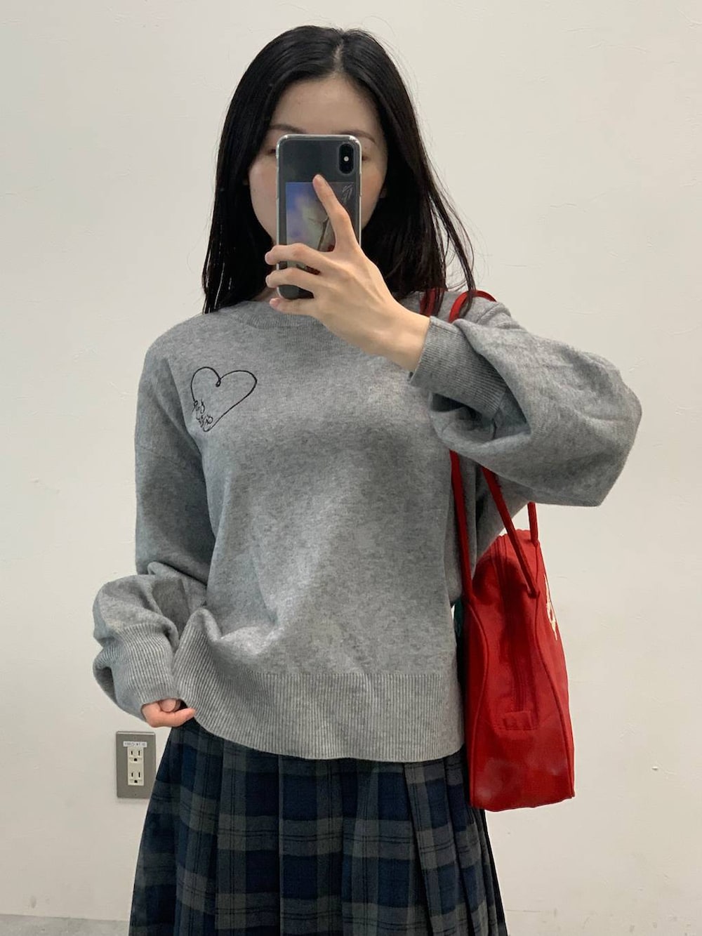 グレー系のニット/セーター、グレー系のスカートを着用したレディースの秋コーディネートの7枚目の写真