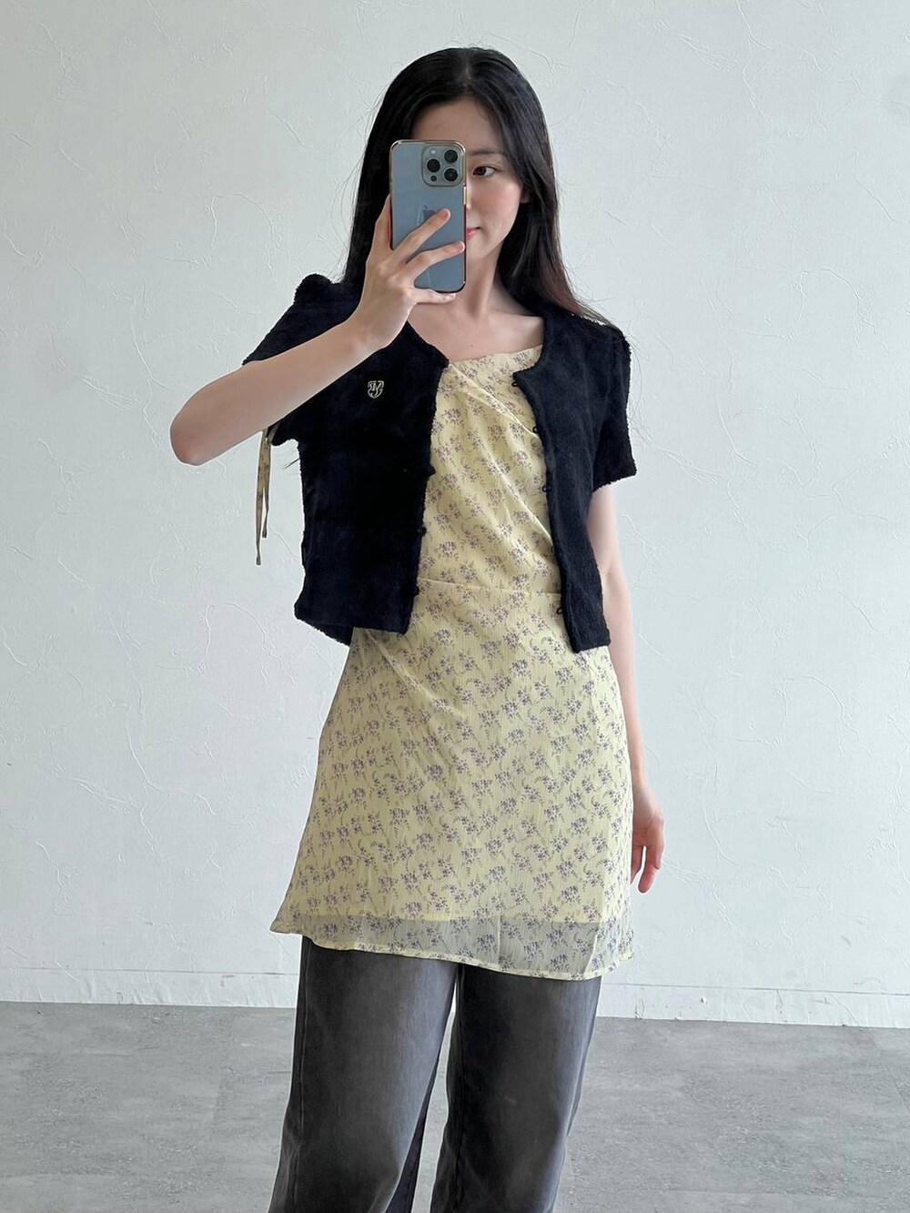 イエロー系のワンピース、ブラック系のトートバッグ、ブラック系のカーディガン/ボレロを着用したレディースの夏コーディネートの5枚目の写真